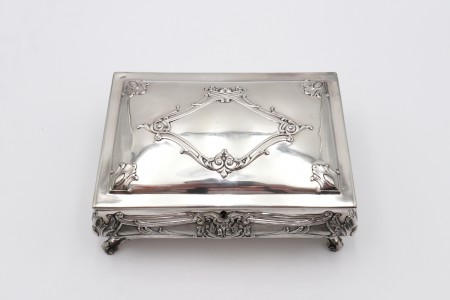 Guarda jóias em prata com alto relevo na tampa e envolvência, quatro pés curvos 